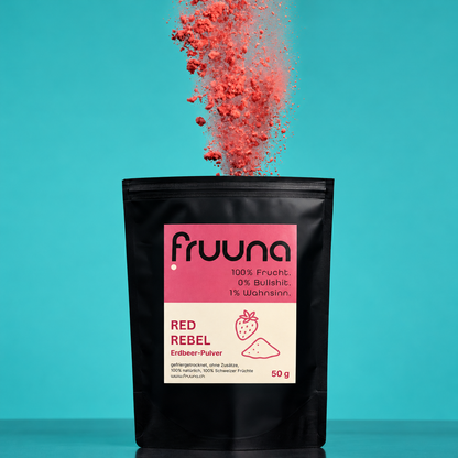 Fruuna Erdbeerpulver 50 g im schwarzen Beutel mit rosa Etikett vor türkisfarbenem Hintergrund.